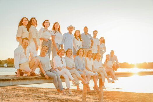 Gruppenbild. Das Team von artistravel auf einem Steg am Strand.