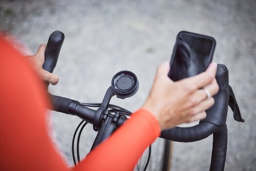 Radfahrer hält Smartphone in der Hand