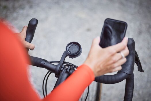 Radfahrer hält Smartphone in der Hand Radfahrer hält Smartphone in der Hand
