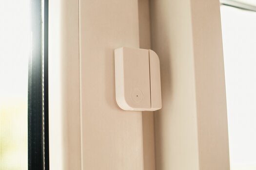 Tür- und Fenstersensor an einem Fensterrahmen montiert. Tür- und Fenstersensor an einem Fensterrahmen montiert.