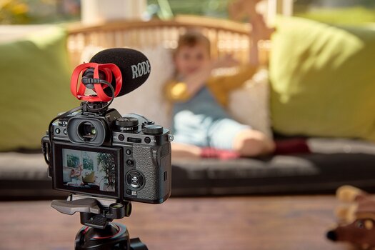VIDEOMICRO II von RØDE an Kamera auf Stativ nimmt eine Szene mit einem Kleinkind im Hintergrund des Bildes auf.