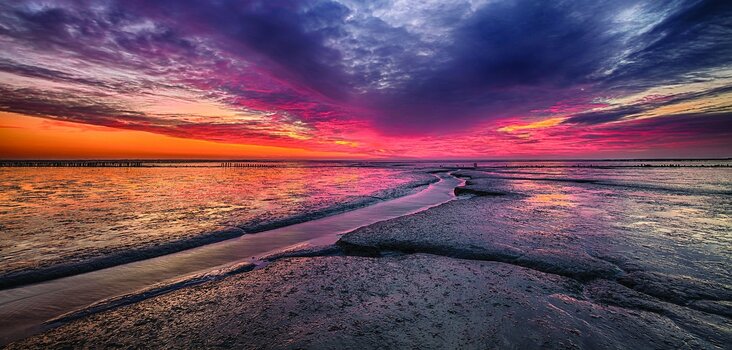 Das Wattenmeer auf Amrum im rotglühenden Sonnenlicht Das Wattenmeer auf Amrum im rotglühenden Sonnenlicht