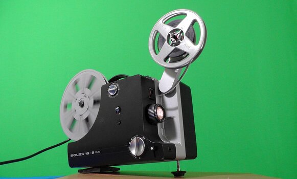 Laufender Filmprojektor vor grünem Hintergrund