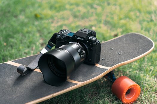Viltrox AF 75 mm F/1.2 XF Pro an Fuji-Kamera liegt auf einem Skateboard