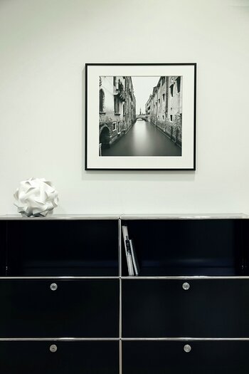 Einzelnes quadratisches Bild im Rahmen über einem Sideboard