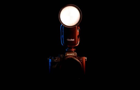 Aufsteckblitz HS Freeze 1s von Rollei auf einer Sony-Kamera vor dunklem Hintergrund