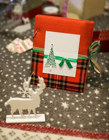 Rotes Fotoalbum mit Schottenkaroeinband weihnachtlich dekoriert Rotes Fotoalbum mit Schottenkaroeinband weihnachtlich dekoriert