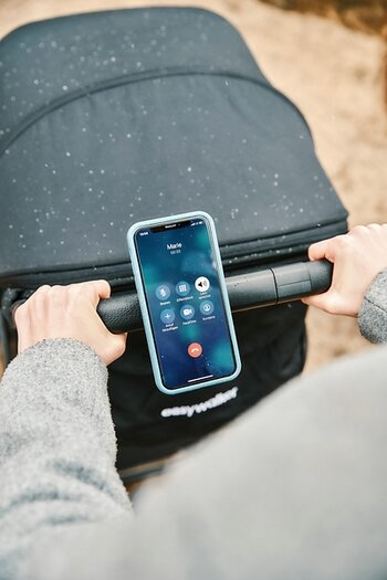 Smartphone am Griff eines Kinderwagens befestigt Smartphone am Griff eines Kinderwagens befestigt