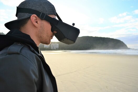 FPV-Drohnenpilot mit VR-Brille am Strand FPV-Drohnenpilot mit VR-Brille am Strand