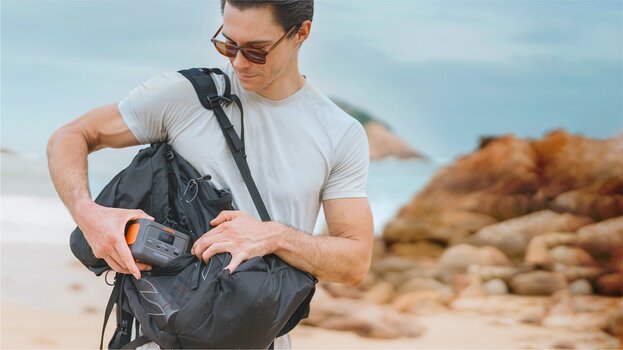 Mann steckt Mini-Powerstation Explorer 100 Plus in eine umgehängte Reisetasche