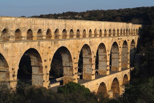 Das römische Aquädukt Pont du Gard in Südfrankreich im warmen Licht der tiefstehenden Nachmittagssonne.
