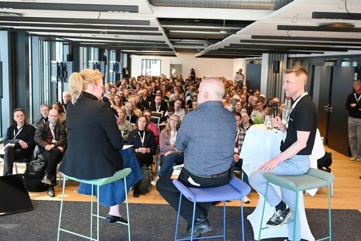 Referenten während eines Fachvortrags auf der Visuals Conference vor großem Publikum. Referenten während eines Fachvortrags auf der Visuals Conference vor großem Publikum.