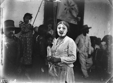 Historische Schwarz-Weiß-Fotografie von Hans Heinrich Brüning aus dem Jahr 1896, die Domitila mit bemaltem Gesicht während eines Karnevals zeigt.