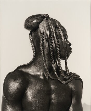 Skulptural wirkende Schwarz-Weiß-Fotografie von Herb Ritts mit einem Mann, dessen Kopf und Schultern von einem Oktopus umhüllt werden. Skulptural wirkende Schwarz-Weiß-Fotografie von Herb Ritts mit einem Mann, dessen Kopf und Schultern von einem Oktopus umhüllt werden.