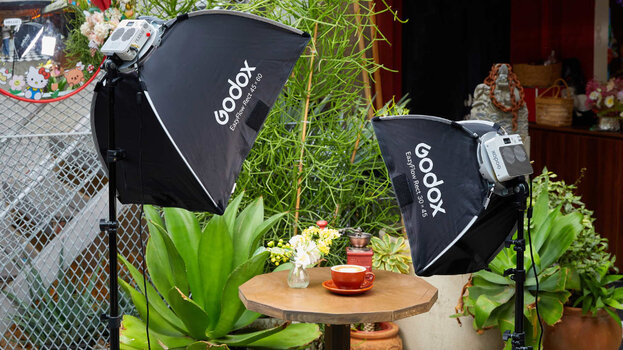 Zwei einsatzbereite Godox EazyFlow Rechteck-Softboxen (Modelle 45x60 und 30x45) auf Stativen, aufgebaut an einem Outdoor-Tisch mit einer Kaffeetasse