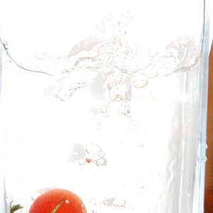 eine Tomate die ins Wasser fällt