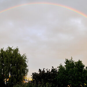 Ein vollständiger Regenbogen, zusammengesetzt aus zwei aus der Hand geschossenen Bildern.