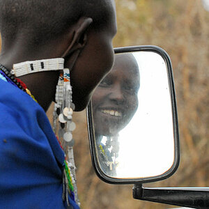 Spieglein Spieglein am Land Rover,
sehe ich so aus?
Maasaifrau sieht sich zum ersten Mal im Spiegel.
0016
