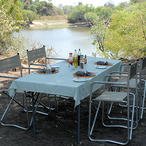 Tischlein-Deck-Dich
Das Mittagessen wurde in den Busch verlegt.
Am Lufupa River wurden mit dem Boot die Tische, Stühle, Kochutensilien und der Grill t