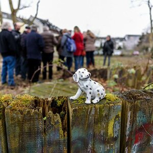 Porzellanhund vor Menschengruppe