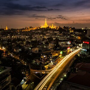 Above all - Der Blick auf die fantastische Shwedagon Pagode in Yangon, nachts von einem Häuserdach.