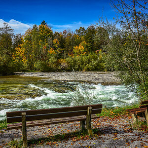 zwei Ruhebänke an der rauschenden Isar