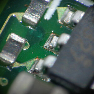 Mit selbstgebasteltem Lupenobjektiv (Maßstab 1:5):
Kleines IC auf einer kleinen Nikon-AF-S-Motorplatine,
Fokus auf den Füßen des IC