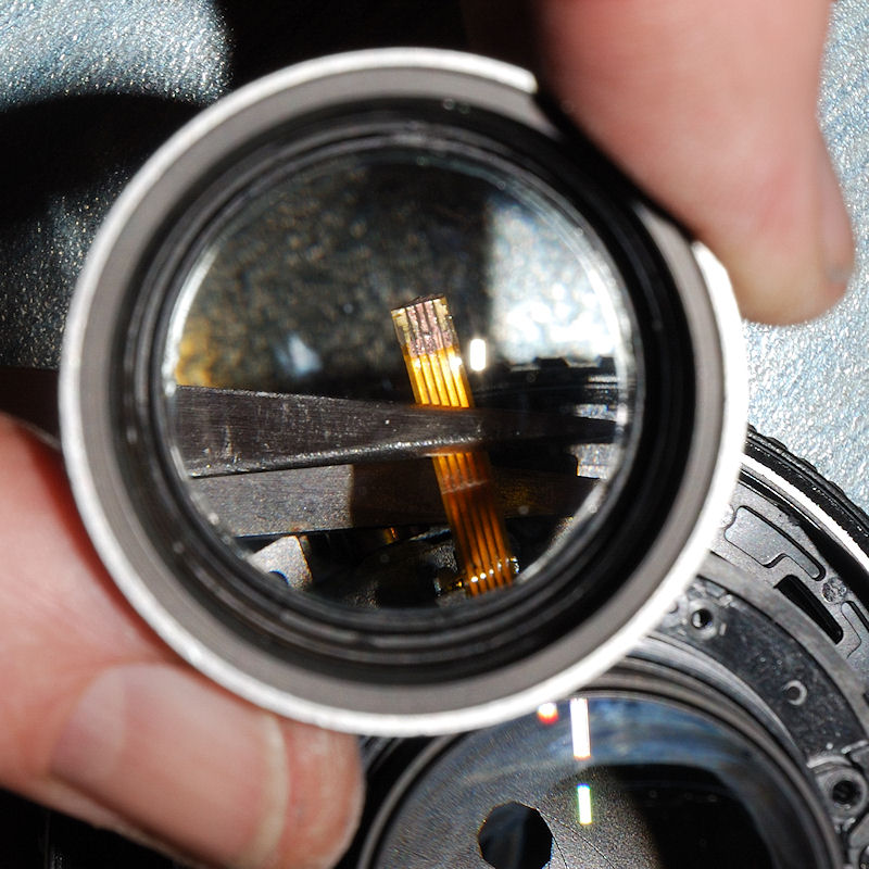 AF-S 50/1.4G mit Seewasserschaden:
Das völlig zerfressene Steck-Kontakt-Ende des FPCs das den Hall-Geber des Fokustriebs mit der Motorsteuerung auf de