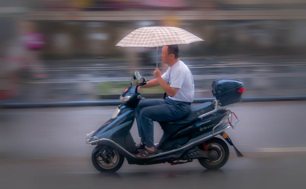 Biker in Beijing an einem verregneten Tag