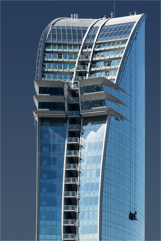 Das W-Hotel in Barcelona - an der rechten Fassade geht ein Fensterputzer seiner "Lebensaufgabe" nach. In den oberen, rechten "Erkerfenstern" spiegelt 