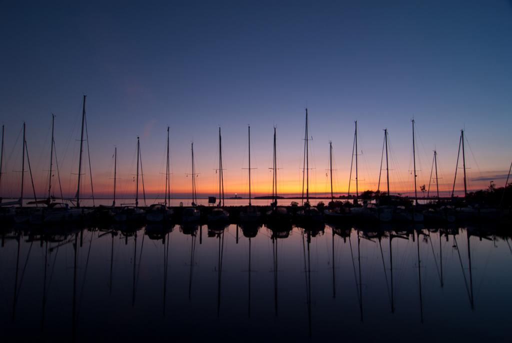 Der Hafen von Orth auf Fehmarn, im Hintergrund ist der Leuchtturm Flügge zu erkennen.