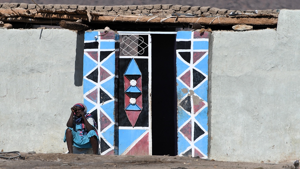 Die Eingangstür ist im Sudan etwas ganz besonders.
Jede Tür ist anders und immer bunt dekoriert

s760 Sessabi Frau Tür 5355