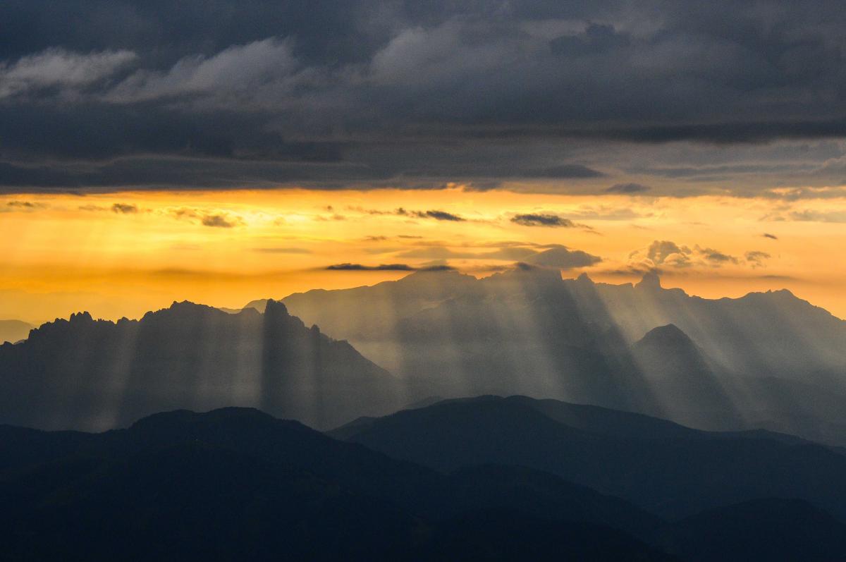 die Sonne bahnt sich ihren Weg über Gosaukamm und Dachstein