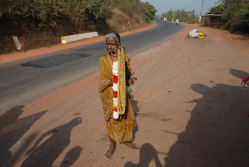 Old indian woman selling flowers on the road (Goa)