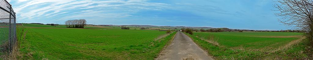 Panorama einer Landschaft.
Mit Photoshop wurde anschließend der Himmel noch etwas blauer gestaltet und das Gras grüner.