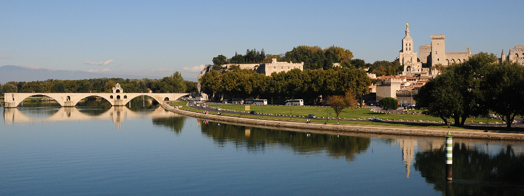 Panorama von Avignon: Rechts der Papstpalast, links der Pont St. Bénézet mit dem Mont Ventoux im Hintergrund.