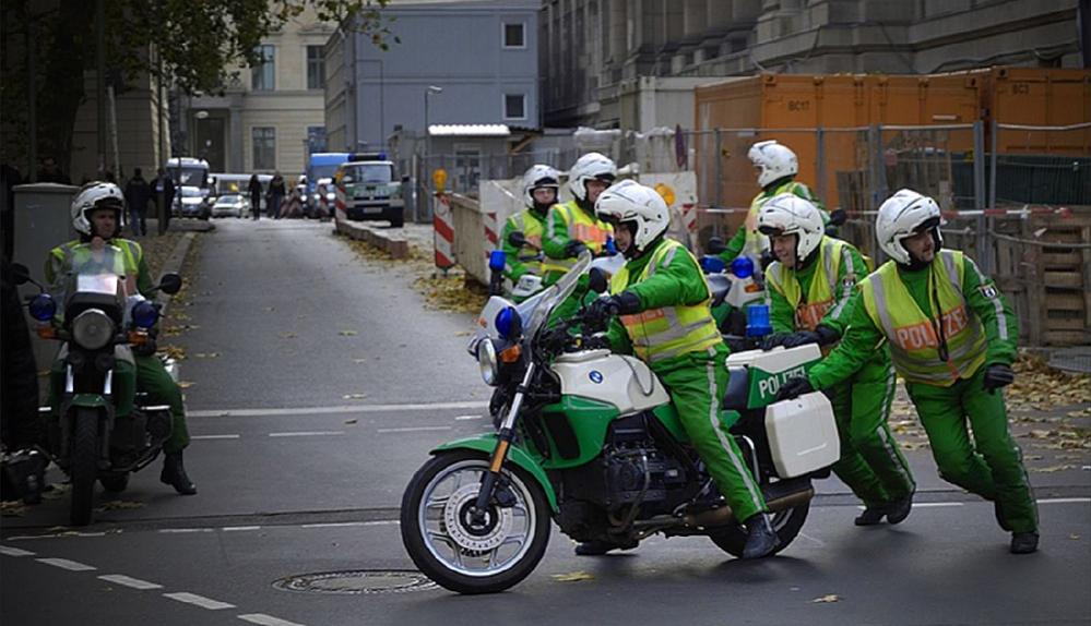 Polizisten schieben das Motorrad ihres Kollegen an