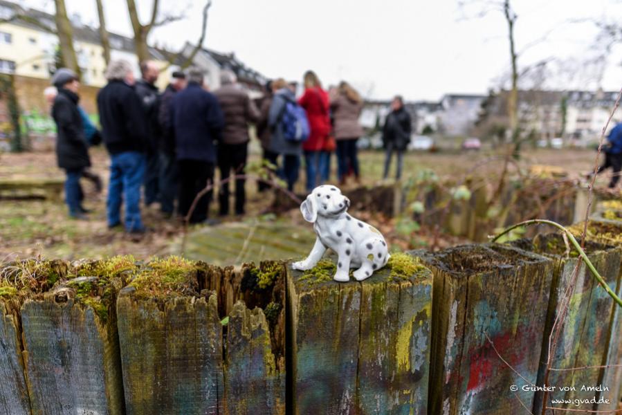 Porzellanhund vor Menschengruppe