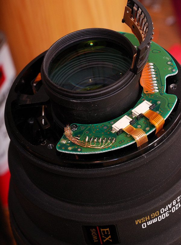 SIGMA AF 120-300mm f/2.8 D APO HSM für Nikon mit Sturzschaden und abgerissenem GMR-Flexikabel.
Das reparierte GMR-Geber-Flexikabels ist angeschlossen,