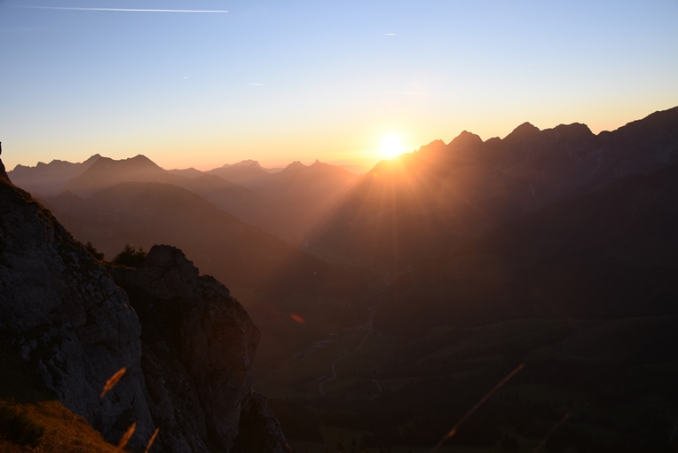 Sonnenuntergang über den Freiburger Voralpen. Unnatürliches rotes Band um die Sonne.