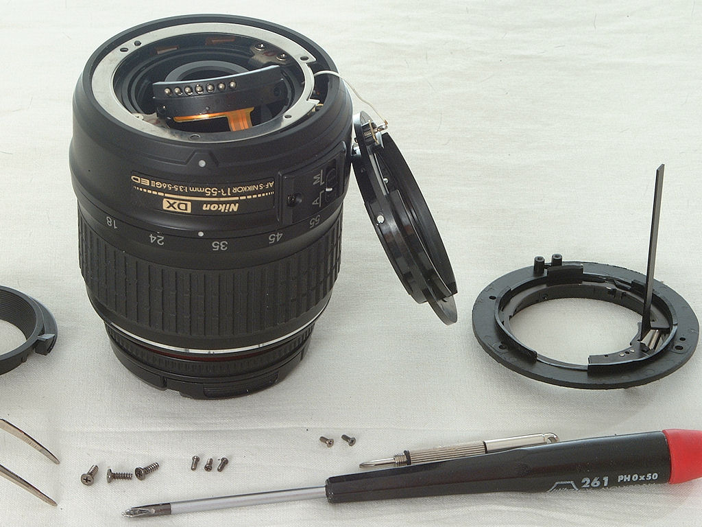 Tausch des Kunststoff-Bajonetts an einem AF-S DX Nikkor:
4.) die Schraube mit welcher der am weissen Kabel angelötete Massestift im alten Bajonett fes