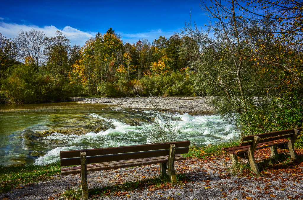 zwei Ruhebänke an der rauschenden Isar
