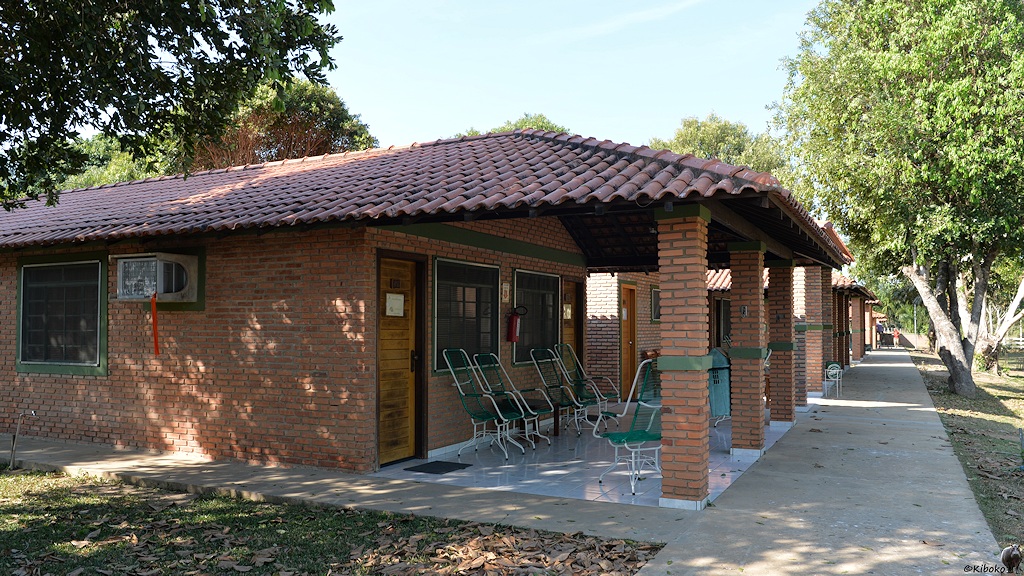 Hütten aus rotem Backstein mit großer Veranda