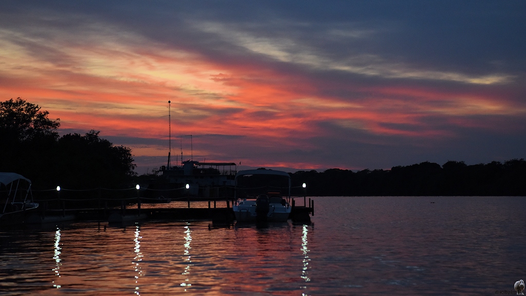 Morgendämmerung mit rot gefärbten Wolken, die sich im Fluss spiegeln.