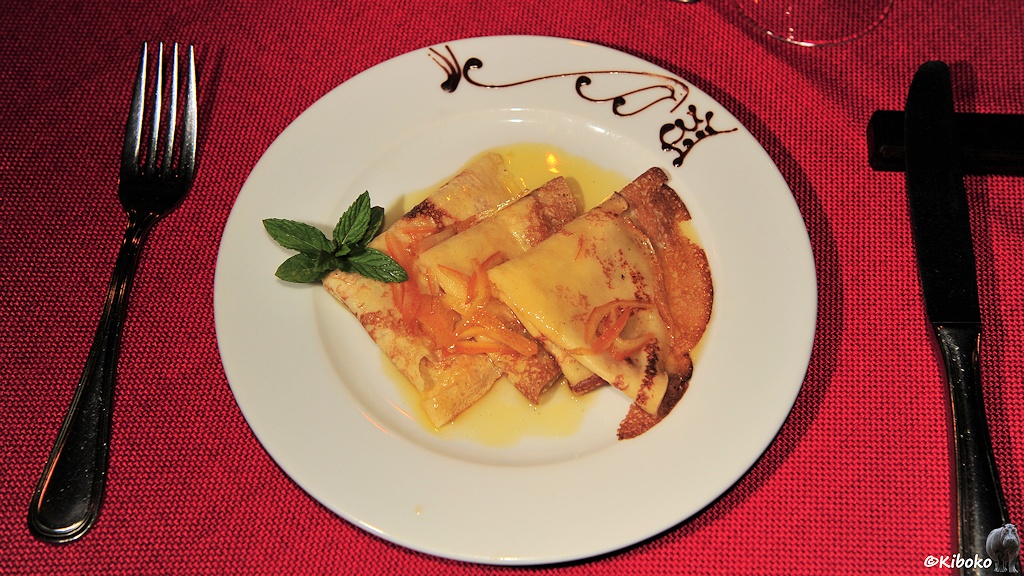 Das Bild zeigt drei zum Dreieck gefaltete Eierkuchen mit Vanillesoße und Minzblätter als Dekoriation.
