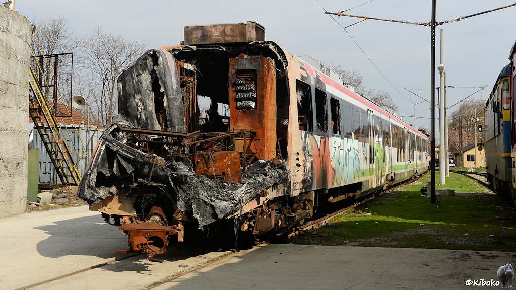 Das Bild zeigt einen modernen weiß-schwarz-roten Elektrotriebwagen, bei dem der Führerstand total zerstört und ausgebrannt ist.