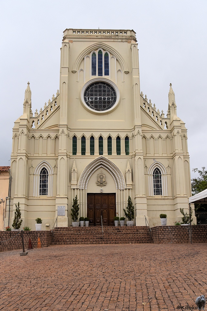 Eingangsportal einer weißen Kirche mit großem Mittelturm