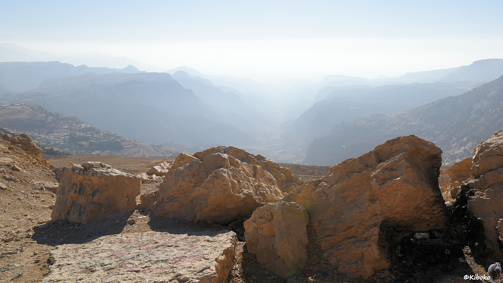 Tal im Dunst mit Felsen im Vordergrund