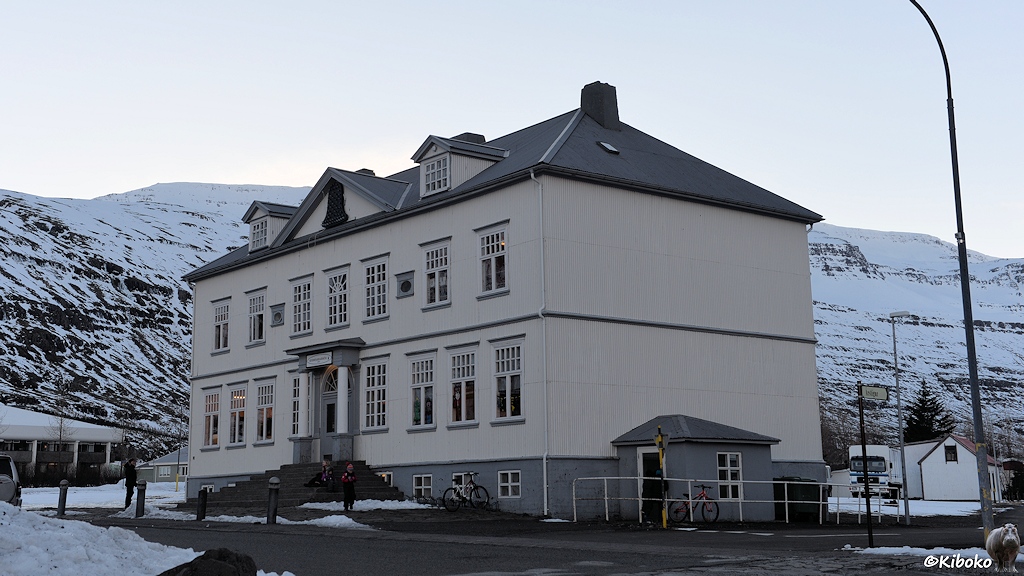 Großes, zweistöckiges Holzhaus mit großer Eingangstreppe.