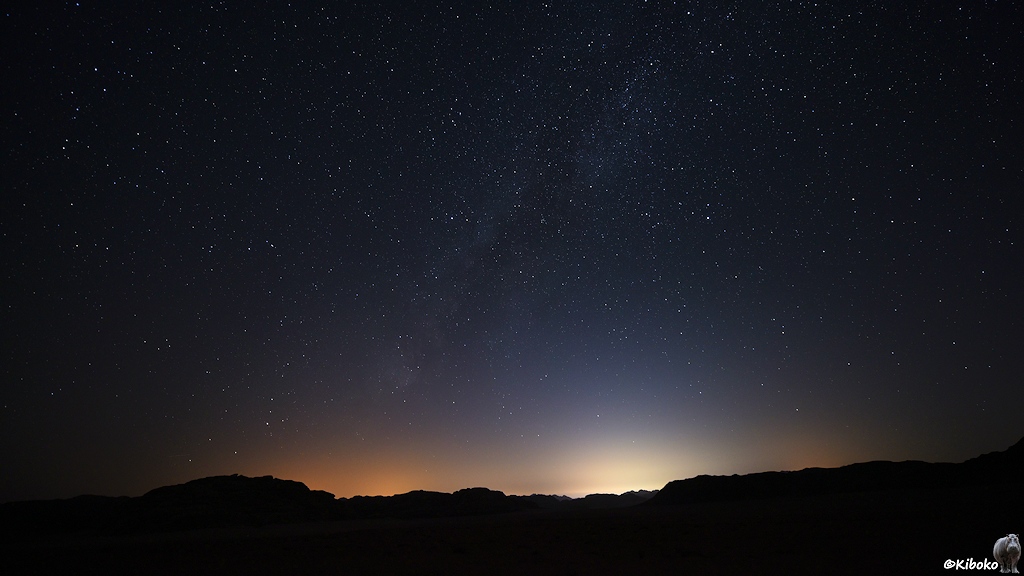 Grelle Lichter am Horizont unter dem Sternenhimmel